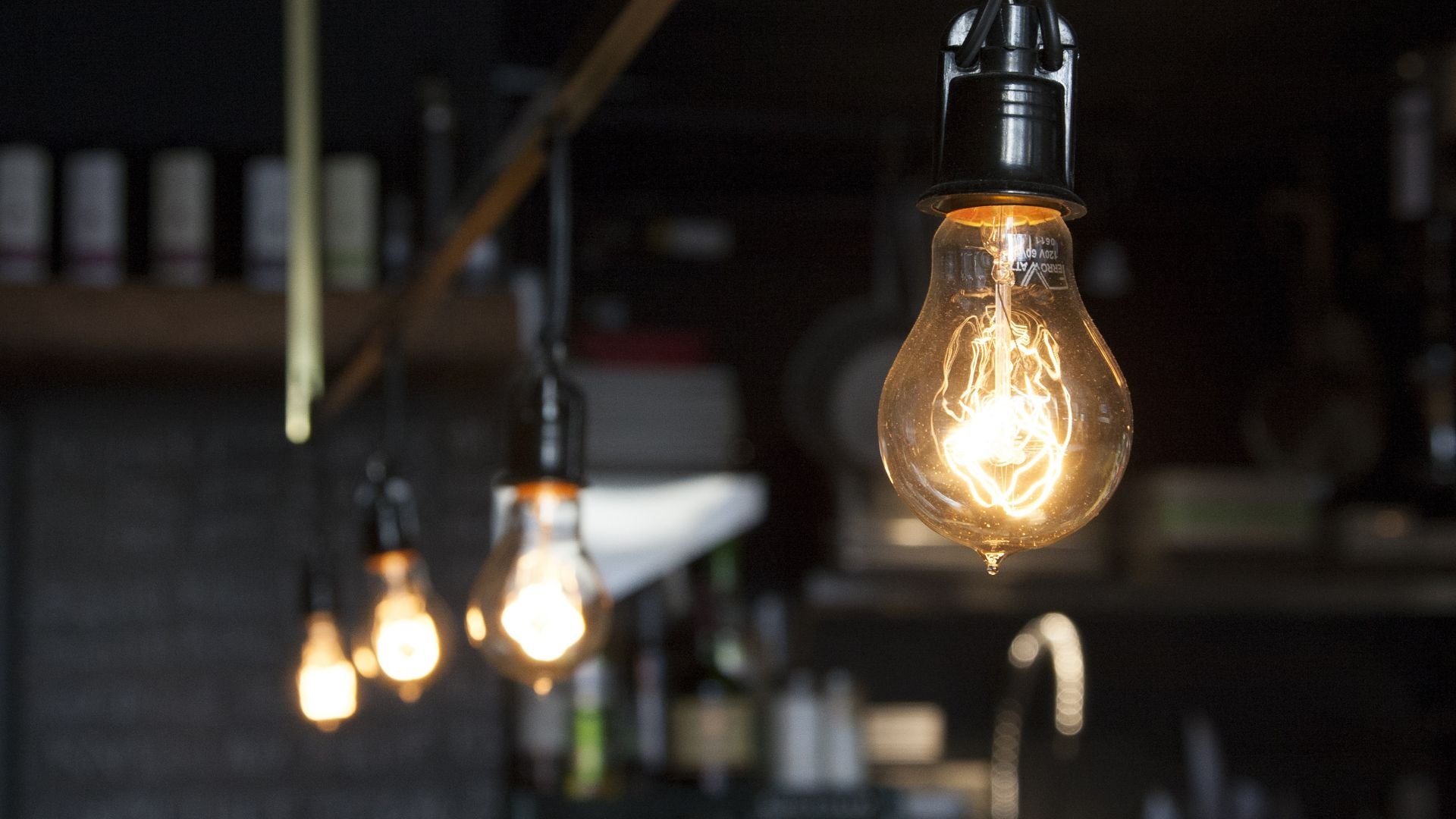 Glowing vintage light bulbs hanging in a dimly lit industrial space
